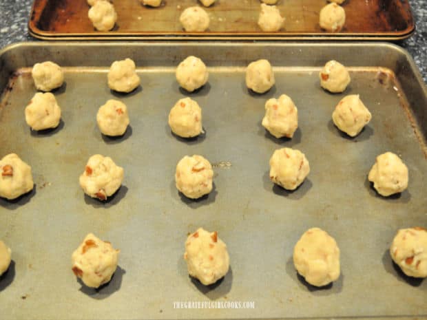 Balls of cookie dough on a baking sheet ready to be baked.