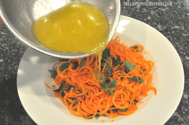 Lemon ginger salad dressing is poured over spiralized carrot salad.