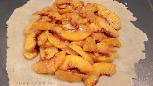 Fresh peaches, with cinnamon and sugar are piled onto free form pastry dough.