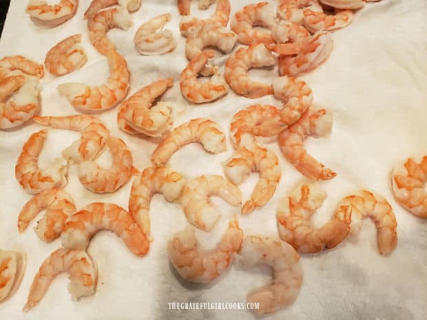 Shrimp are patted dry on paper towels before coating them in batter.