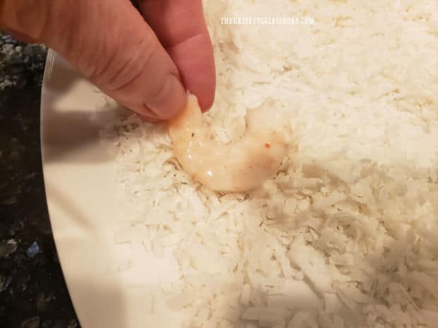 Battered shrimp are rolled in shredded coconut, until covered.