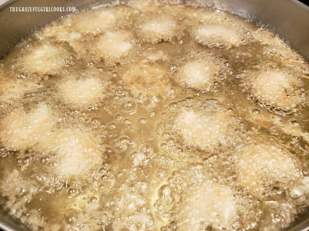 Coconut shrimp are cooked in hot oil in batches until golden brown.