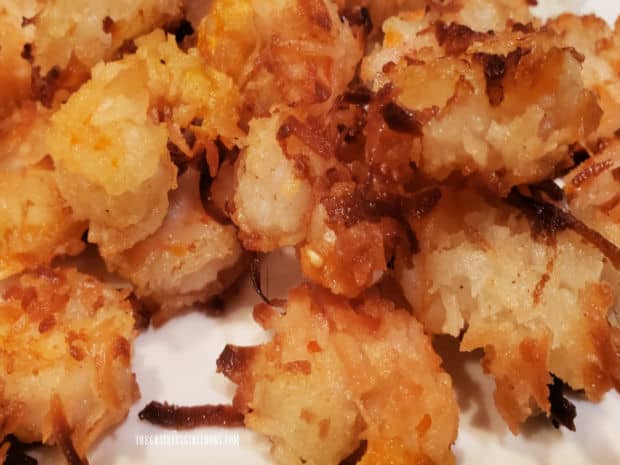 Cooked coconut shrimp are golden brown and crunchy when served.