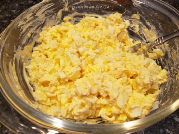 Egg salad is stirred well to combine, then seasoned to taste with salt and pepper.