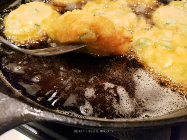 Fried okra fritters are cooked in hot oil until browned on bottom, then flipped.