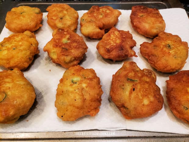 The fried okra fritters are put on paper towels to absorb excess oil.