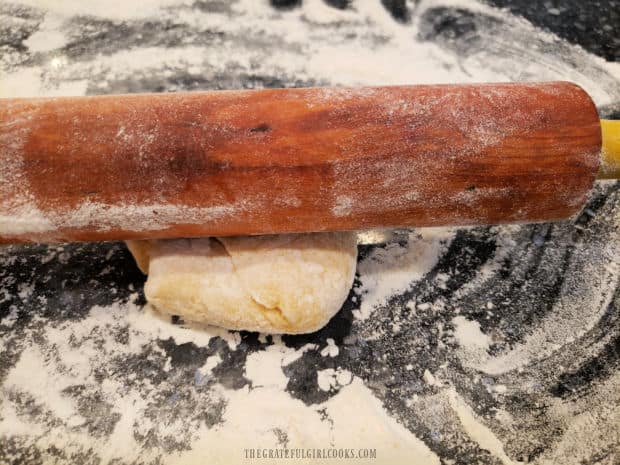 A rolling pin is used to roll out the dough for the egg noodles.