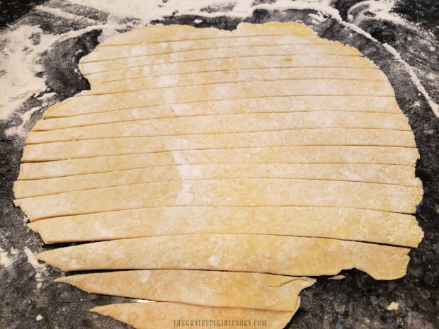 After being rolled out, the dough is cut into thin strips.