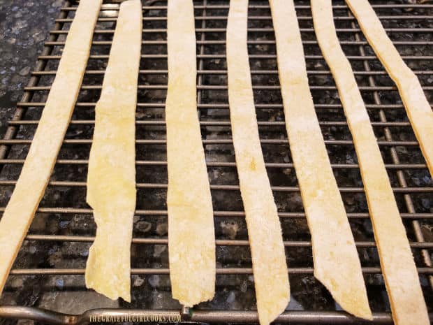 Several of the homemade egg noodles drying on a wire rack.