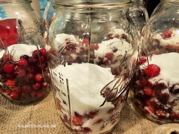 Granulated sugar is added to each jar of cranberries.