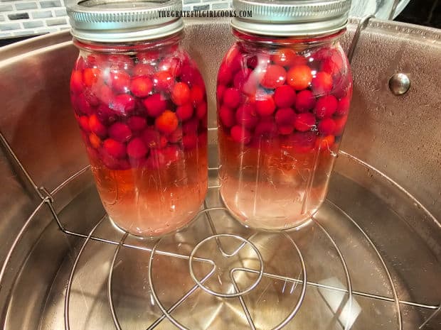 After water is added, the jars are sealed, then placed on canning rack.