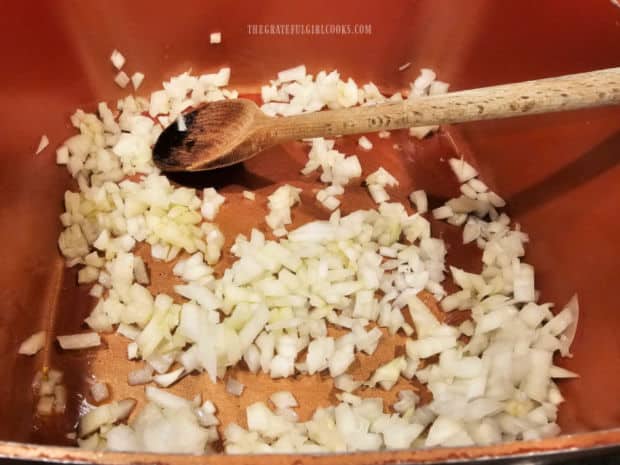 Chopped onions are cooked in olive oil in a large saucepan until tender.