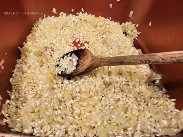 Arborio rice is added into the cooked onions and olive oil.