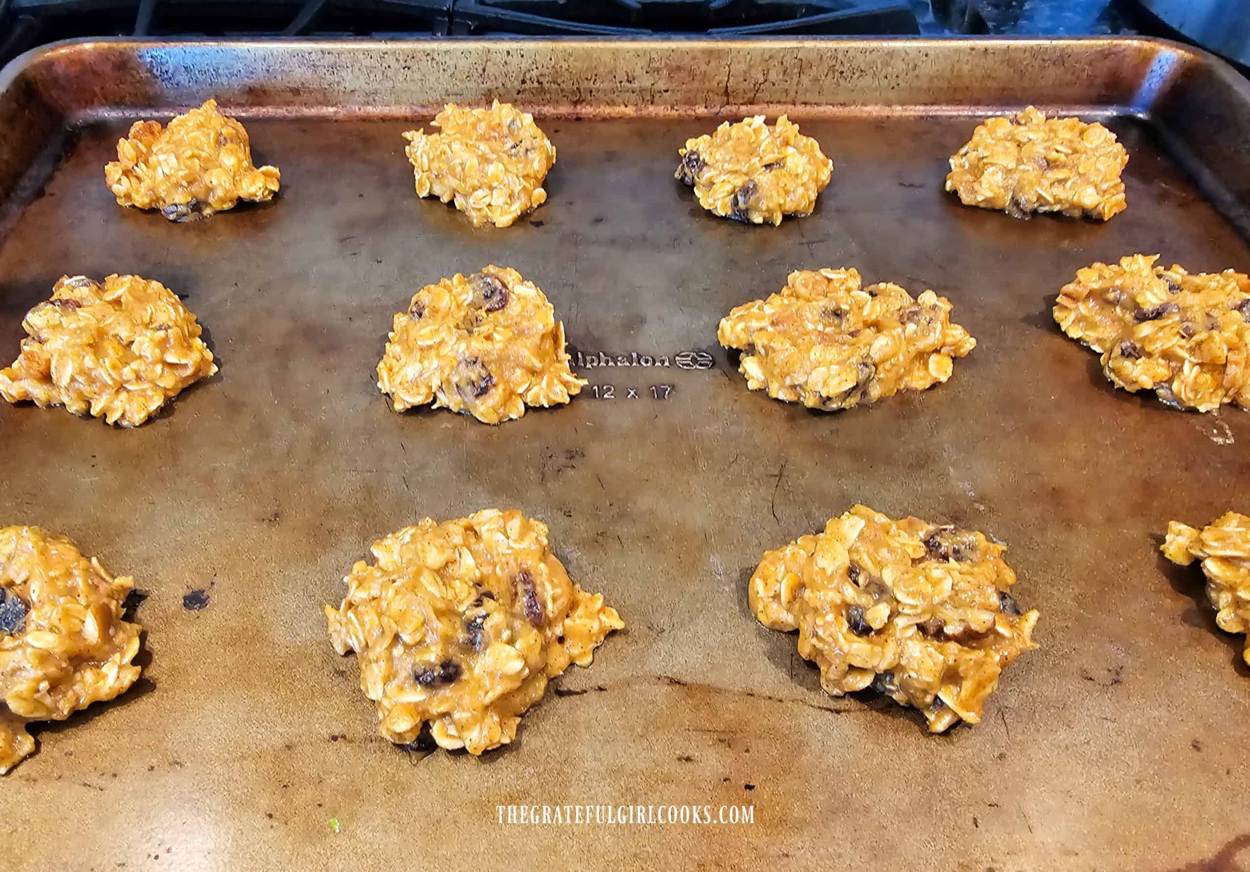 Cookie dough is dropped onto baking sheets, then dough is slightly flattened.