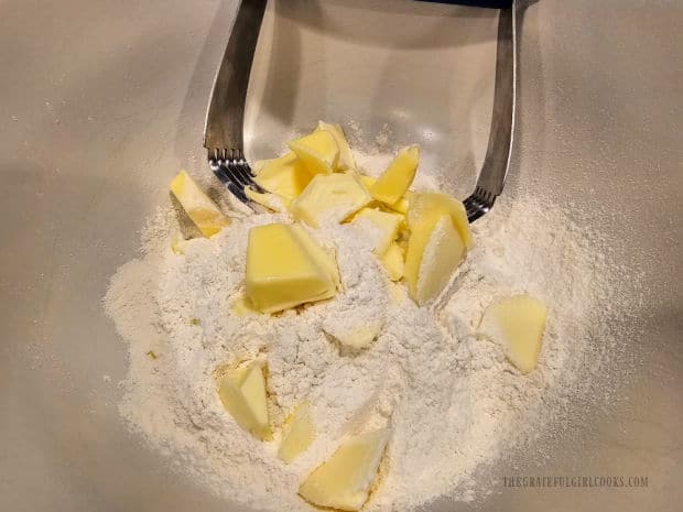 Cold butter is cut into the dry, sifted flour mixture.
