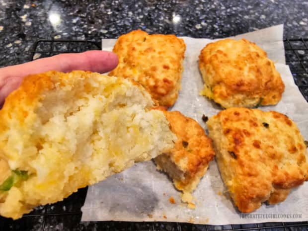 An air fryer cheddar biscuit is cut in half to reveal the soft, fluffy inside.