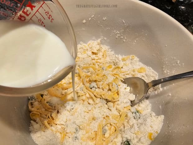 Cold buttermilk is added to the cheddar biscuit dough and stirred to combine.