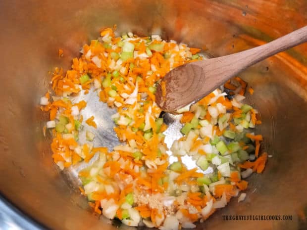 Onion, carrots, celery, and garlic are sautéed in melted butter.
