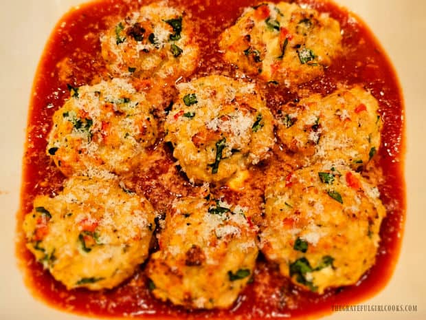 Eight Chicken Ricotta Meatballs For 2 are served on top of marinara sauce.