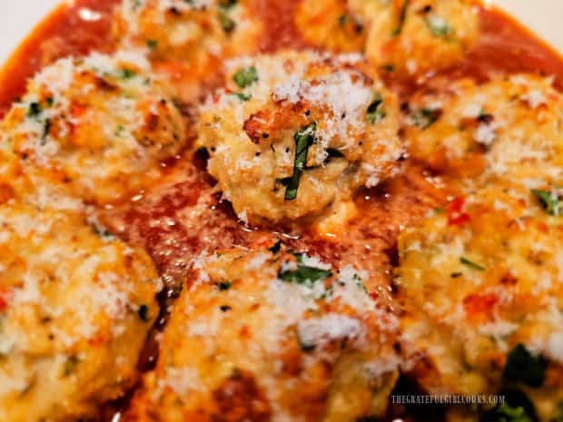 Finely grated Parmesan cheese garnishes the baked chicken ricotta meatballs.