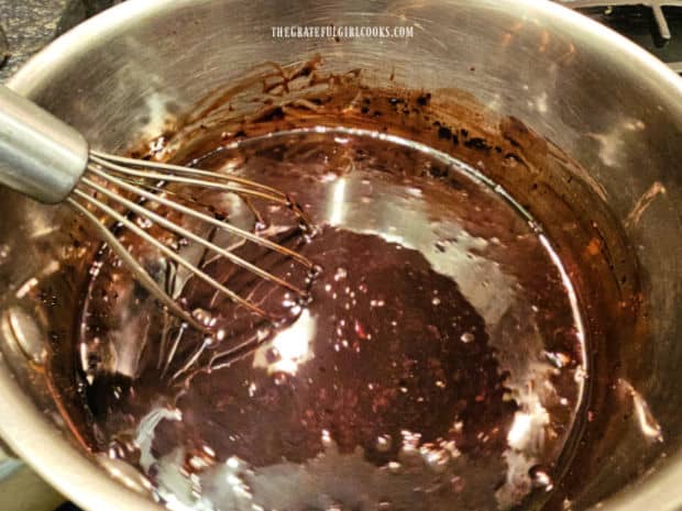 A whisk is used to combine the homemade chocolate syrup ingredients.