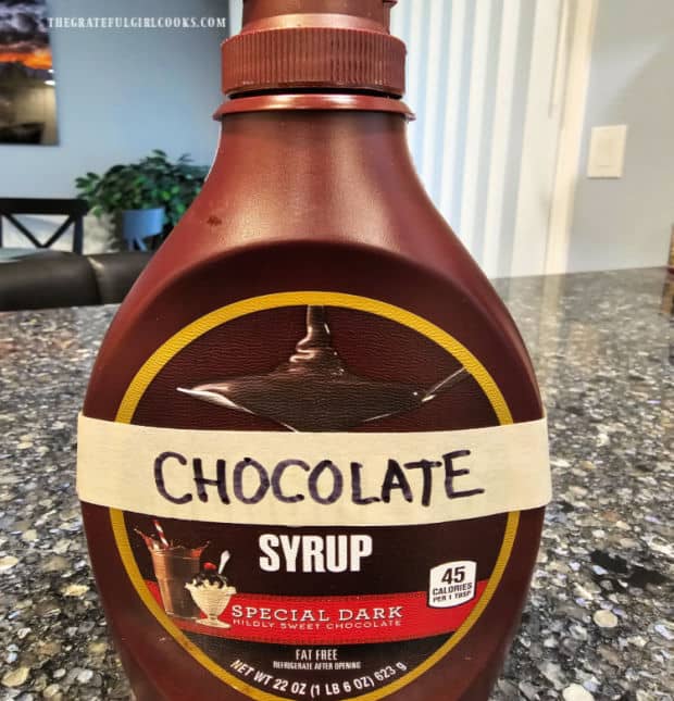 Chocolate syrup is poured into a re-used syrup container for storage.