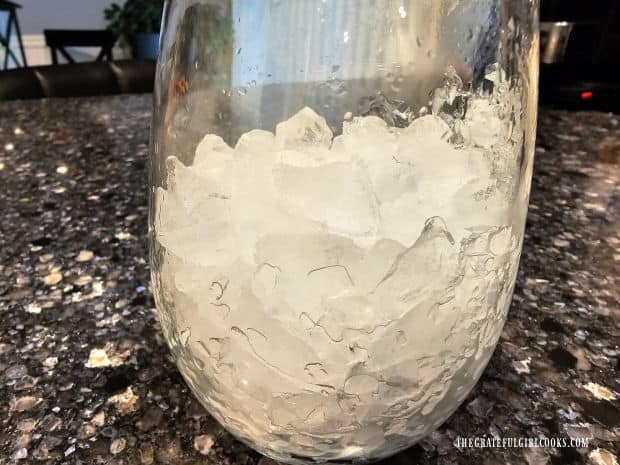 A glass cup is filled with crushed ice before adding the latte mix.