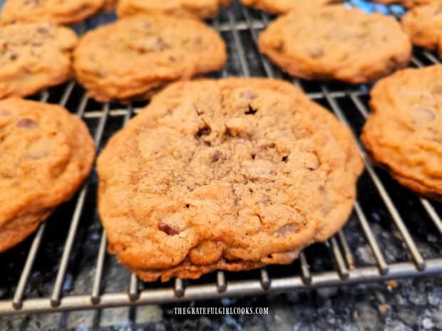 Jumbo chocolate chip cookies are golden brown and cooling on wire rack.