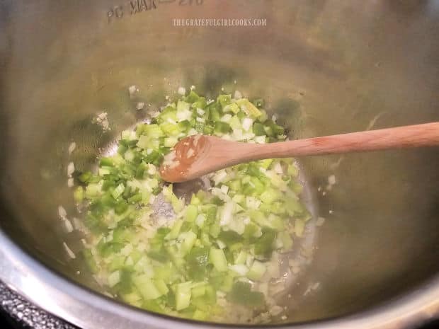 Chopped onion, bell pepper and celery are sautéed in oil in the Instant Pot.