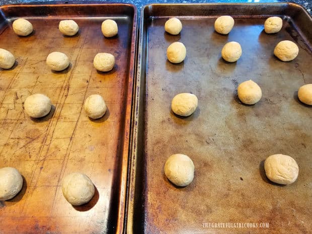 Balls of peanut butter cookie dough on baking sheets 2" apart.