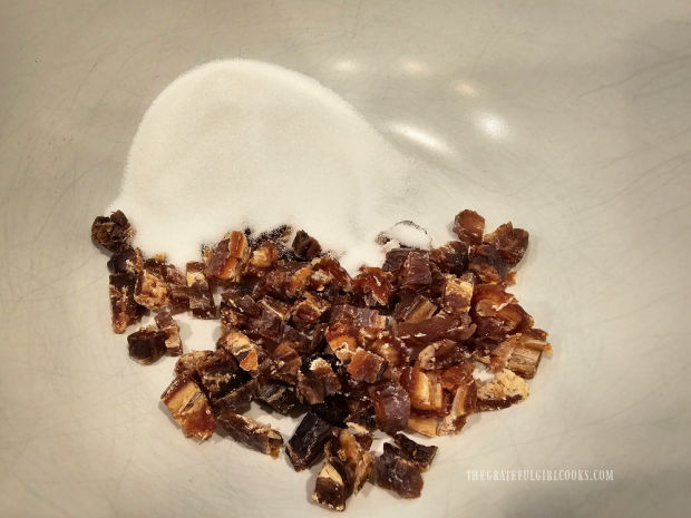 Chopped dates and granulated sugar are placed in a large bowl.