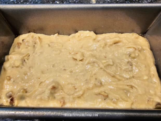 Date nut bread batter is spread evenly in a greased large loaf pan.
