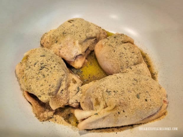 Chicken is covered with olive oil, then spices are added and combined.