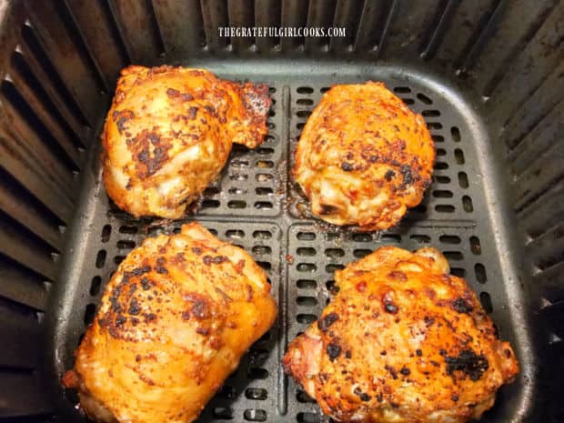 Garlic Herb Chicken Thighs are flipped over halfway through air frying.
