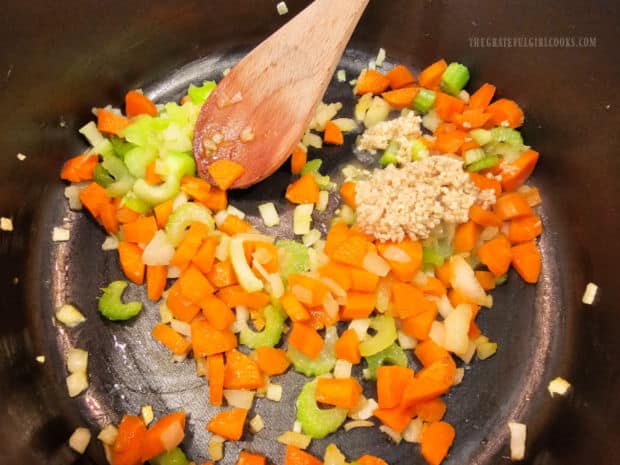 Diced carrots, celery and minced garlic are added to the pan and cooked.