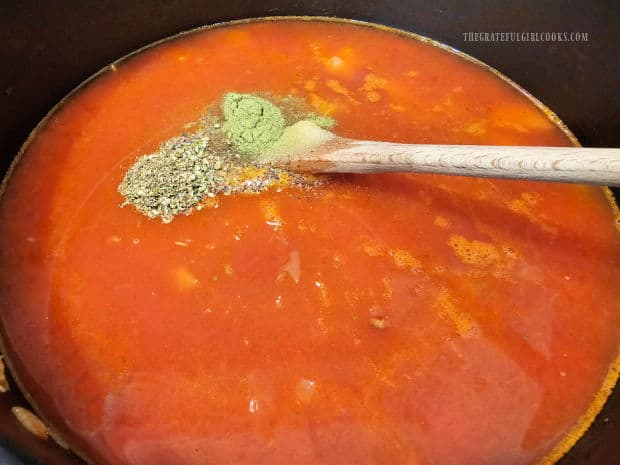 Salt, pepper, oregano and thyme are stirred into the lentil potato soup.