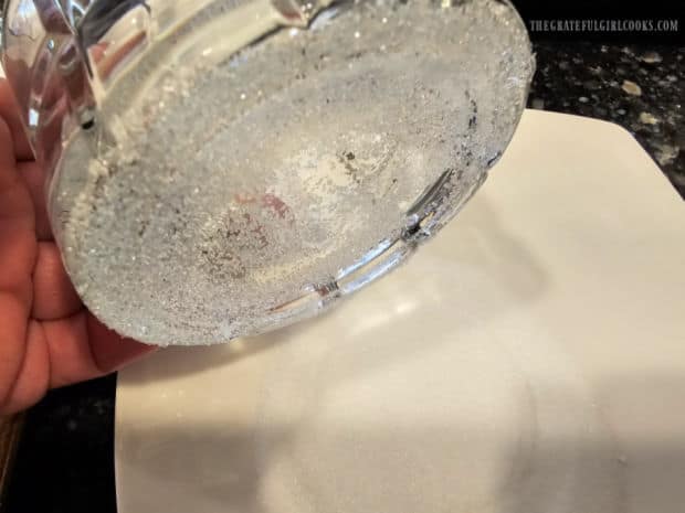 Bottom of a glass is moistened then dipped in sugar.