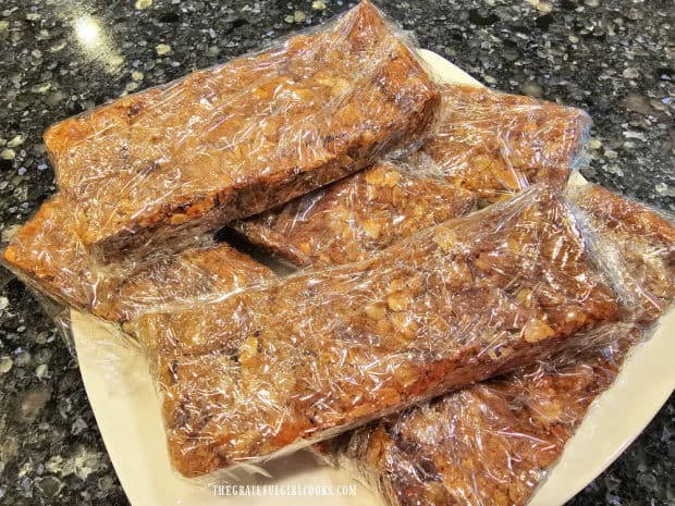 A white plate holding plastic-wrapped chocolate chip granola bars.