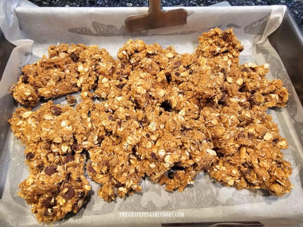 Dough for the granola bars is added to the parchment paper-lined pan.