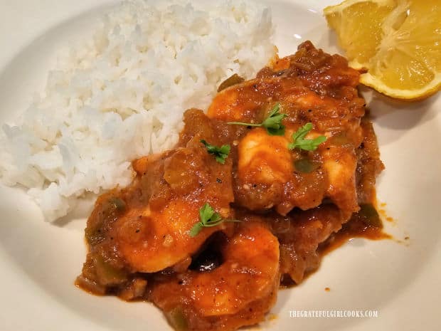 A white bowl, with Creole Shrimp and Rice and lemon slices inside.