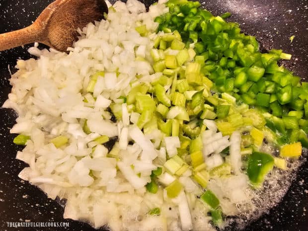 Chopped onions, celery and bell pepper cook in oil and butter in skillet.