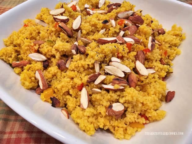 Toasted sliced almonds garnish the golden almond couscous in a bowl.