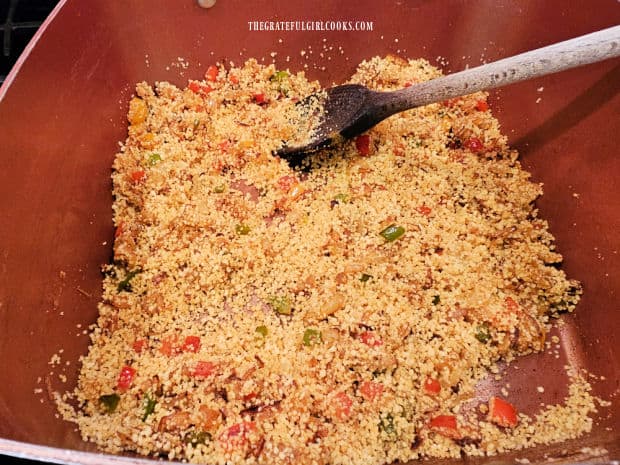 Couscous is stirred into the veggies in the saucepan.