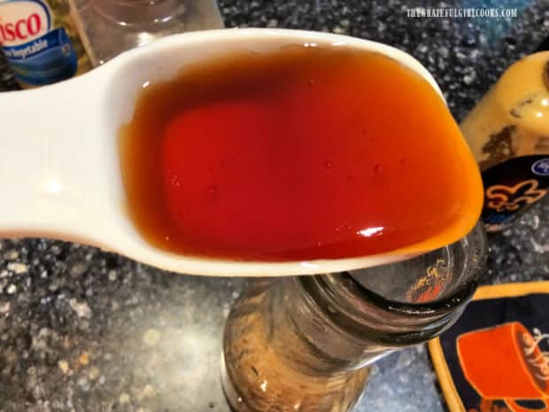 Honey being added to the bottle of homemade salad dressing.