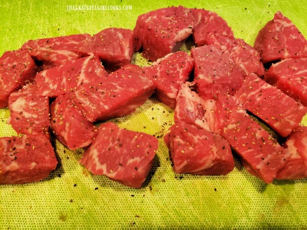 Beef stew meat is lightly seasoned with salt and pepper.