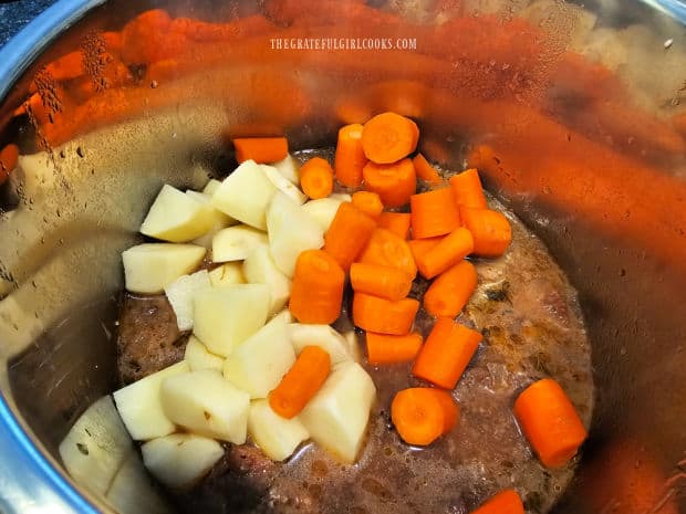 Raw carrot chunks and potatoes are added into the stew and then cooked.