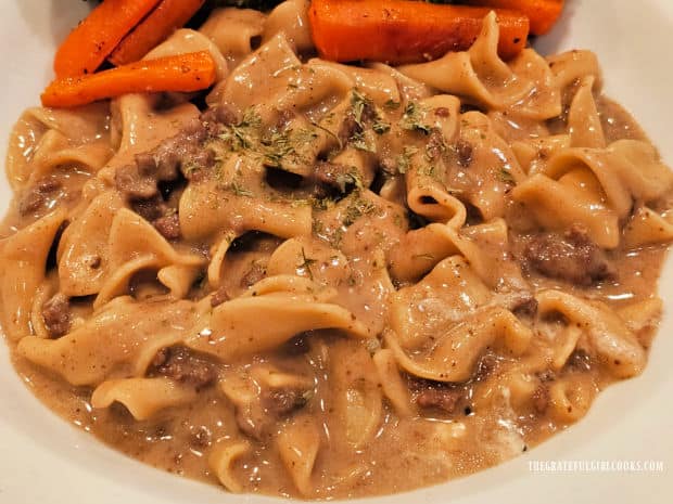 A serving of the stroganoff is accompanied by roasted carrots.