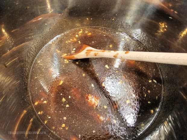 Beef broth and seasonings are added to the Instant Pot.