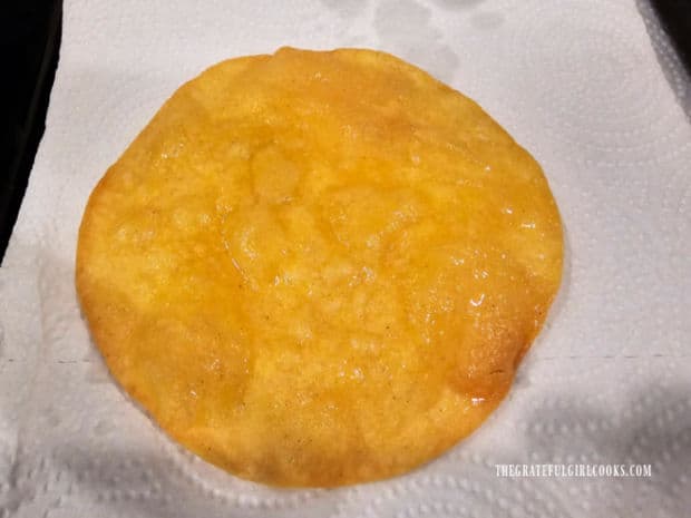 Fried tortilla rests on paper towels used to absorb oil.