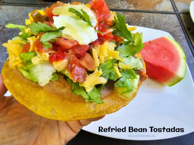 Refried Bean Tostadas are an easy, meatless meal! Corn tortillas are fried until crisp, then topped with beans, cheese, lettuce, salsa, etc.